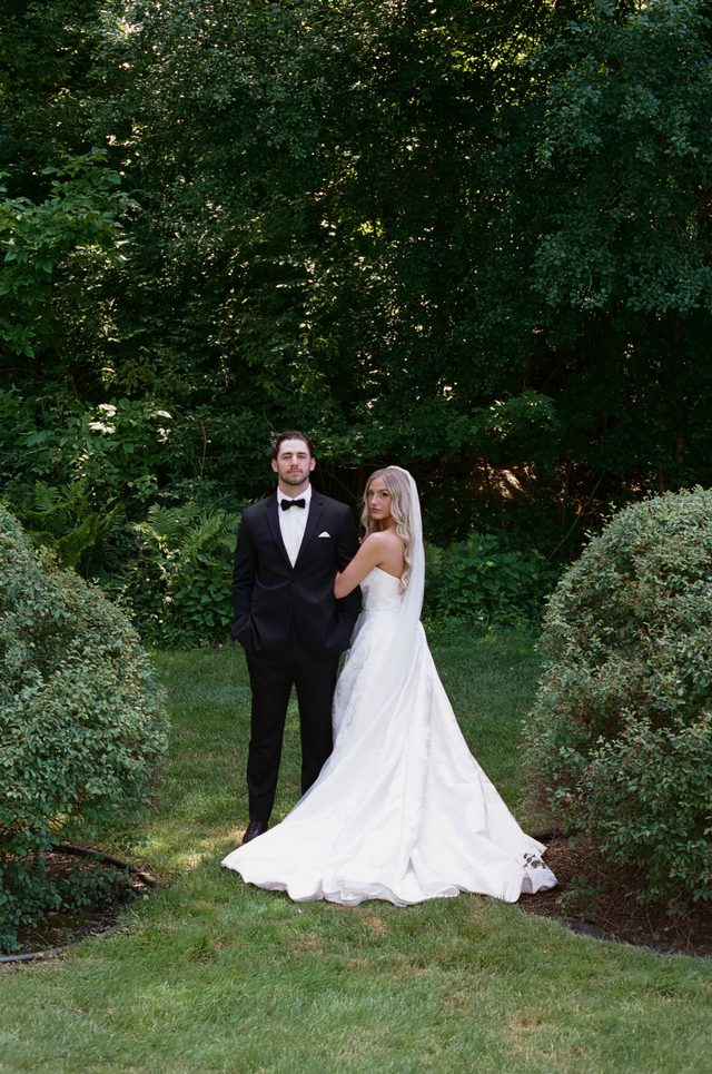 Stephanie and Nick standing together in the gardens at Wellers Carriage House.
