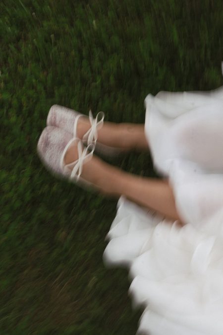 Emma’s bare feet beneath the hem of her dress, caught mid-step.