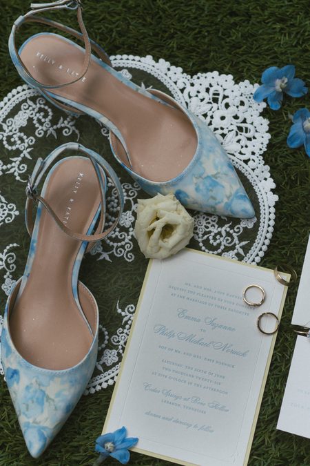 Emma’s blue floral heels laid out with the invitation suite and rings.