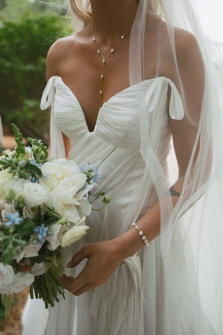 Emma holding her bouquet, her mother’s pearl necklace at her throat.