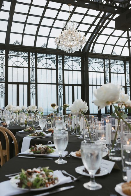 A reception table set with white blooms and candlelight.
