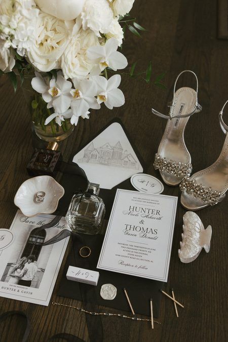 The invitation suite laid out with Hunter's shoes, rings and perfume.