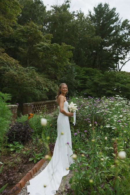 Kendra in the wildflower garden with her calla lily bouquet, a butterfly crossing the frame.