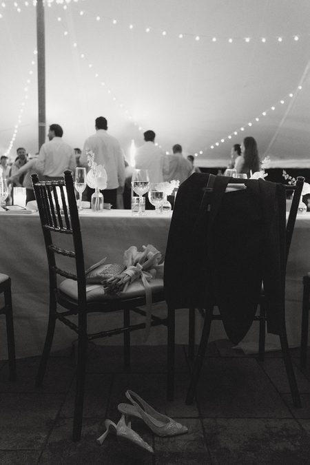 Kendra’s shoes kicked off under the empty head table late in the night, in black and white.