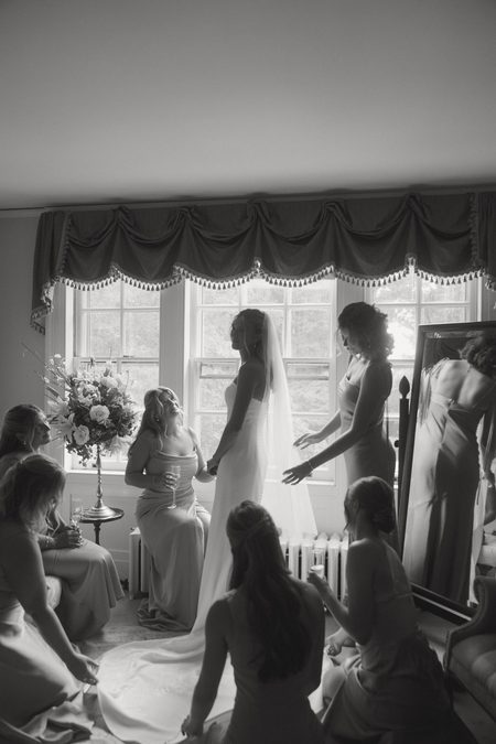Kendra with her bridesmaids in the bridal room, in black and white.