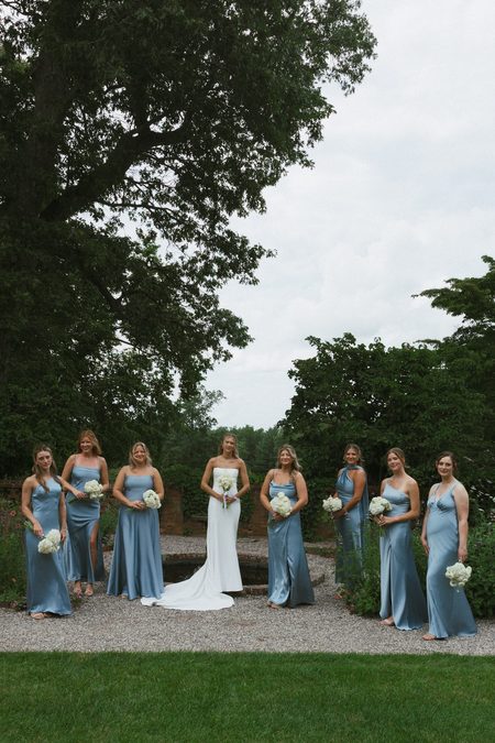 Kendra with her bridesmaids in pale blue on the lawn.