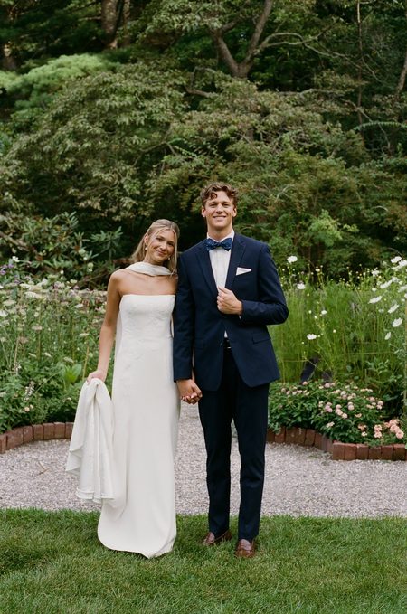 Kendra and Will standing hand in hand on the garden path.