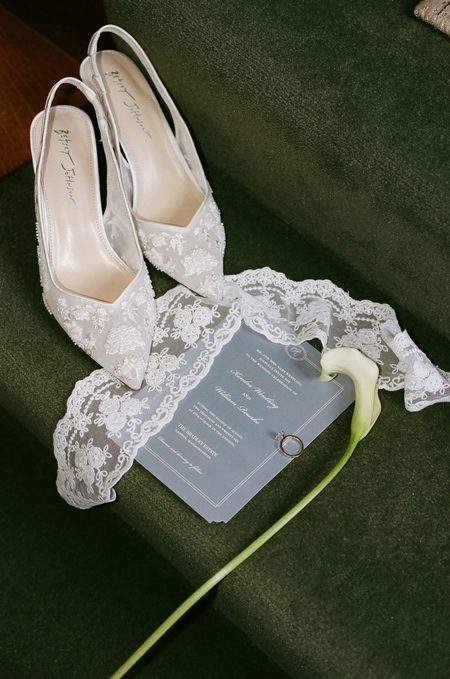 Kendra’s lace heels, the pale blue invitation and a calla lily on green velvet.