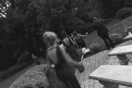 Guests moving through the gardens, caught in motion in black and white.
