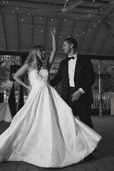 Stephanie and Nick dancing beneath string lights in the pavilion.